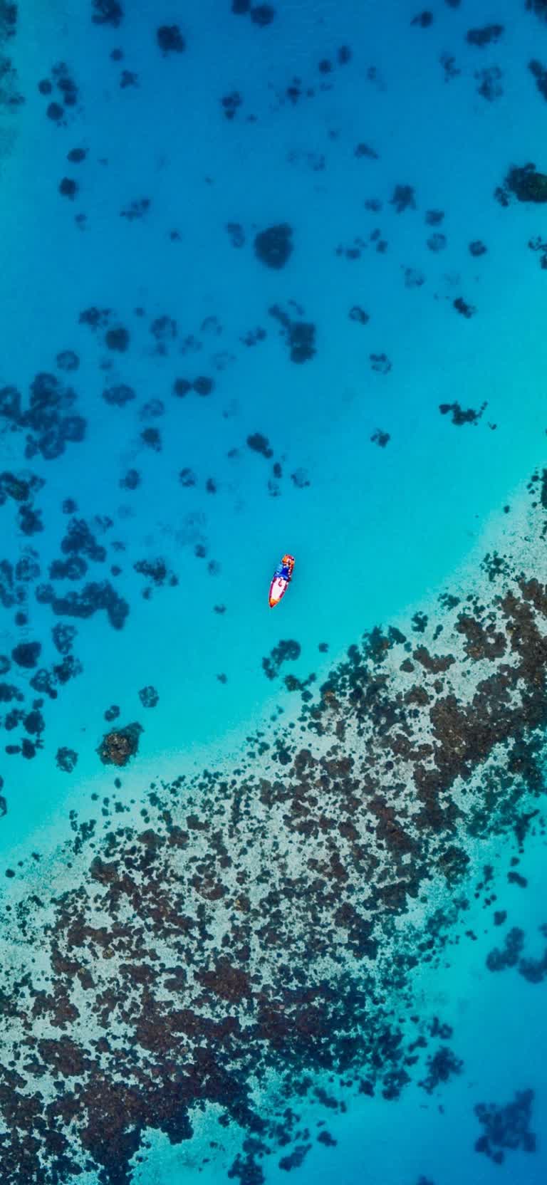 鸟瞰一个人在海洋中滑翔伞