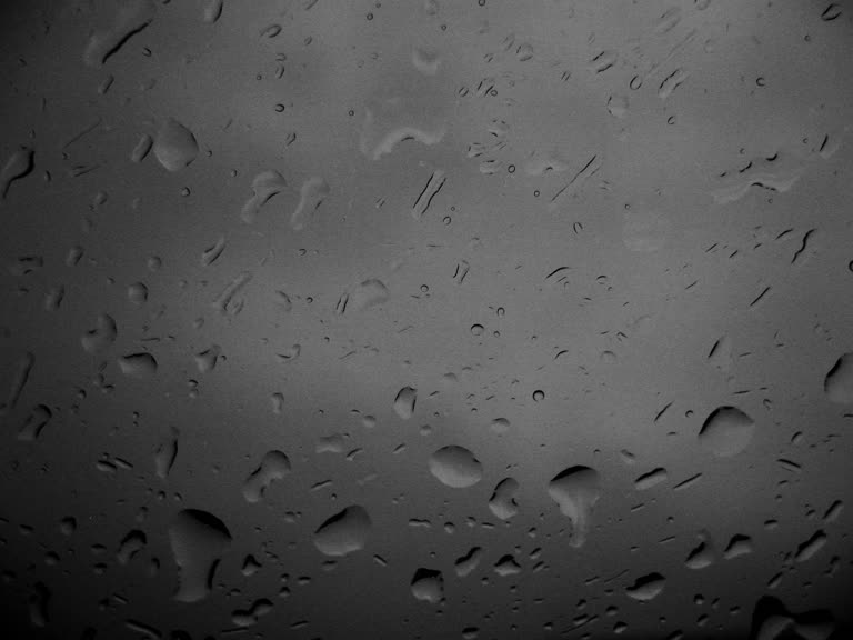窗玻璃上的雨滴黑白照片