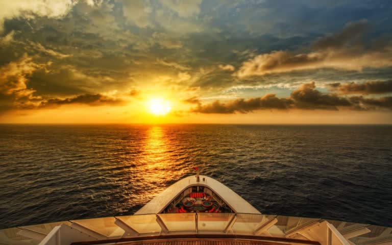 有一艘船在夕阳时分在海洋中航行