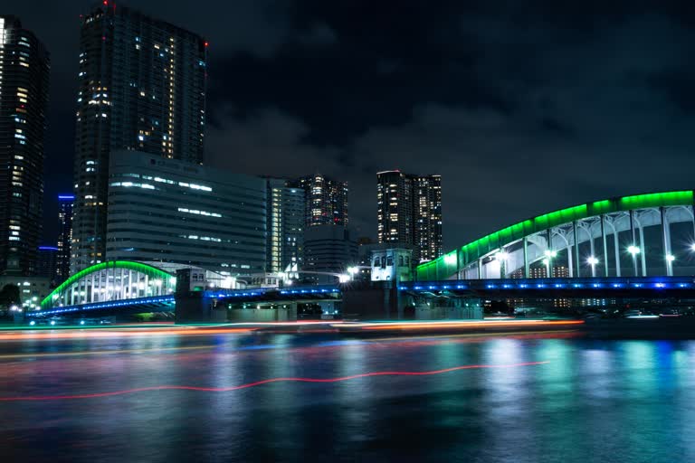 夜间河上灯火通明的桥梁,背景是建筑物