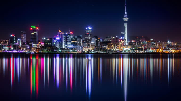 夜晚灯火通明的城市天际线倒映在平静的水面上