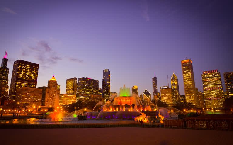 夜晚城市天际线前灯火通明的喷泉