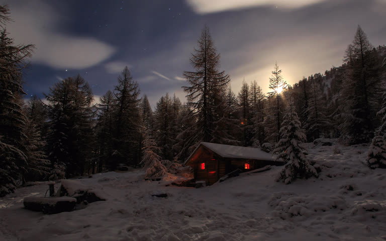 夜晚在白雪皑皑的森林中有一间小木屋