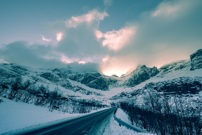 有一辆车在山里的雪路上行驶