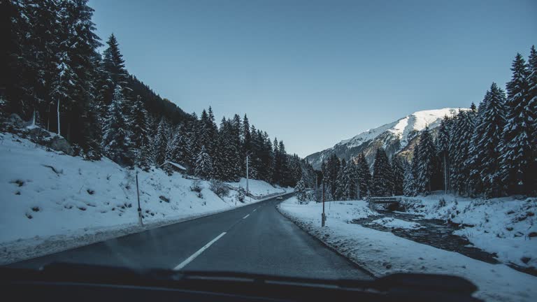 有一辆车在山里的雪路上行驶