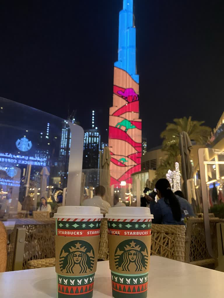 一栋高楼前的桌子上摆着两杯咖啡