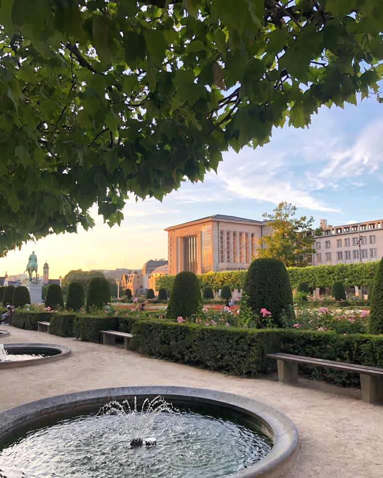 公园中央有一个喷泉,背景是一座建筑物