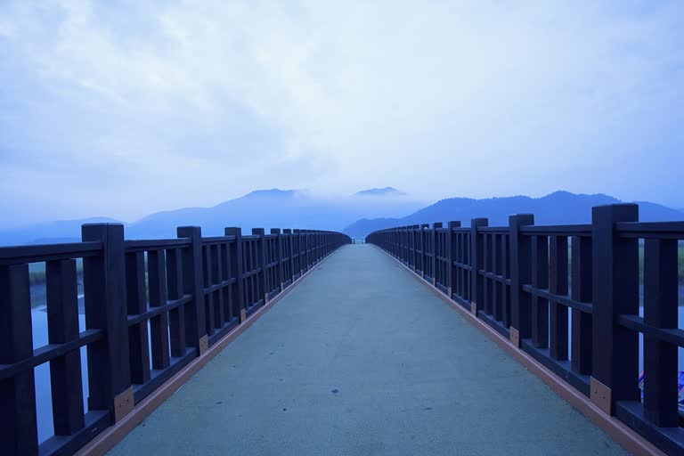 这是一张河上的桥的图像,背景是山脉