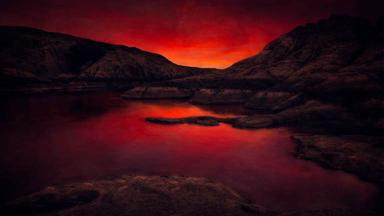这是高山湖泊上红色夕阳的图像