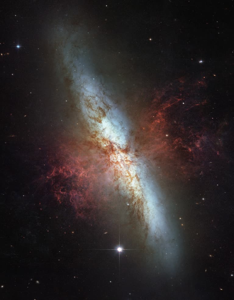 这是一张螺旋星系的图像,背景中有一颗恒星