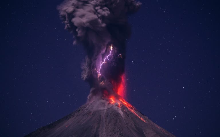 火山喷出熔岩和熔岩向夜空喷出的照片