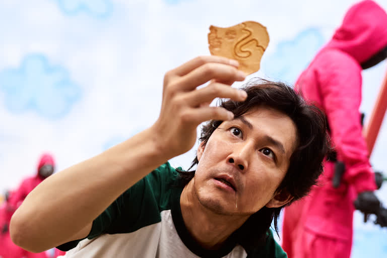 有一个男人,手里拿着一块饼干