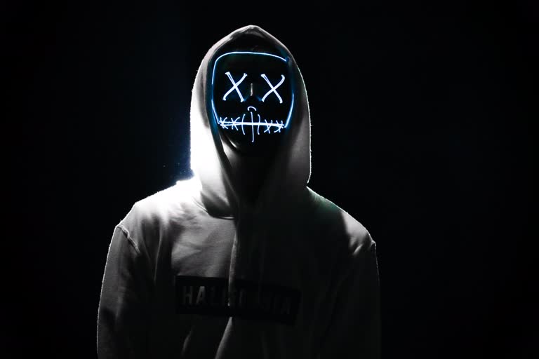 有一个穿着连帽衫、戴着霓虹灯面具的男人