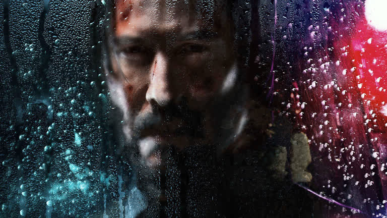 有一个男人在雨中从窗户向外看