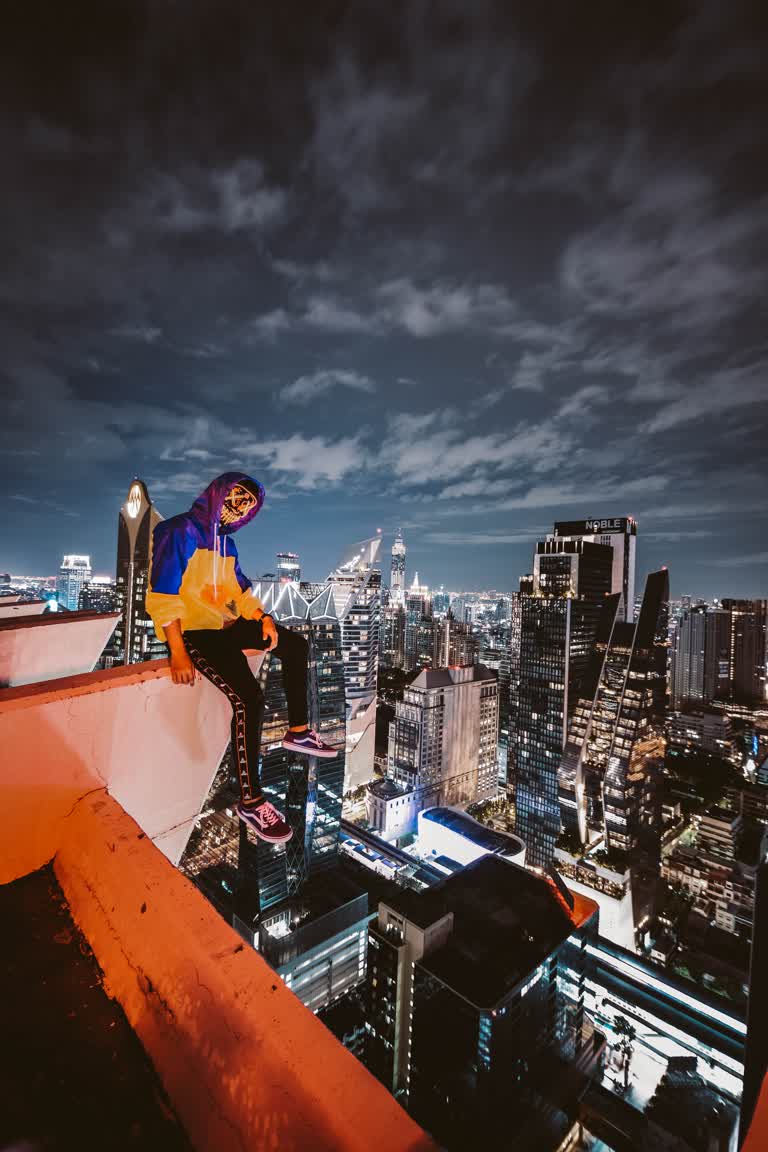 有一个人坐在一栋建筑的边缘