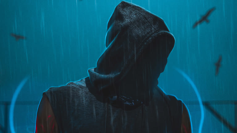 有一个男人站在雨中,头上戴着兜帽