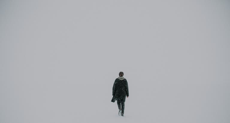 有一个男人站在雪地里滑雪板