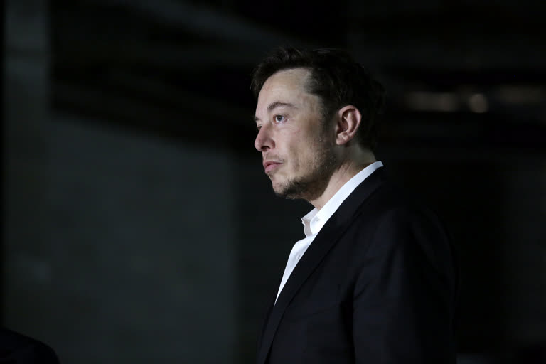 一个西装打领带的男人站在黑暗的房间里