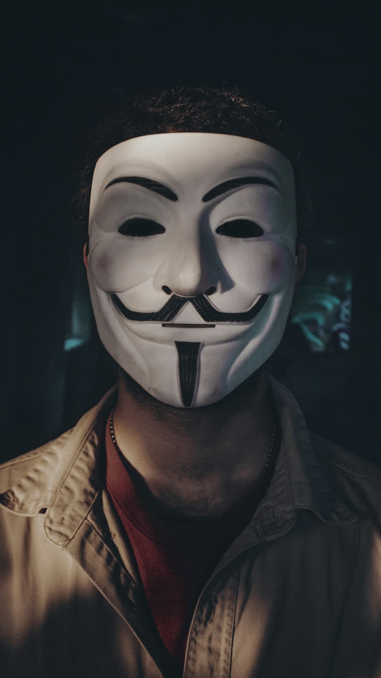 有一个男人戴着男人面具,打着红色领带