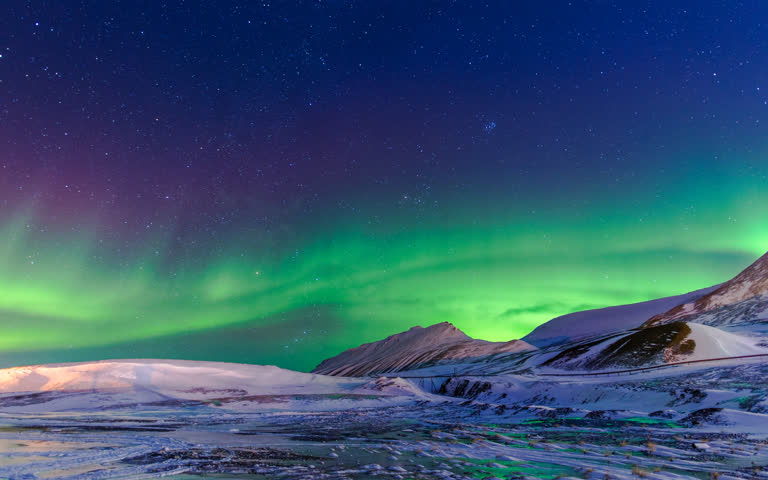 白雪皑皑的山峦和夜空中的绿灯