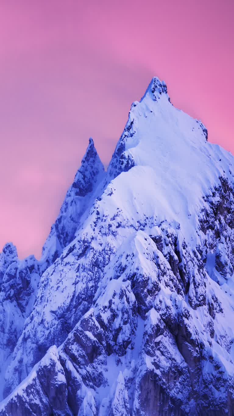 白雪覆盖的山脉,背景是粉红色的天空