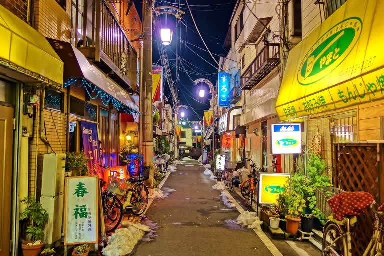 有一条狭窄的街道,建筑物上有很多标志