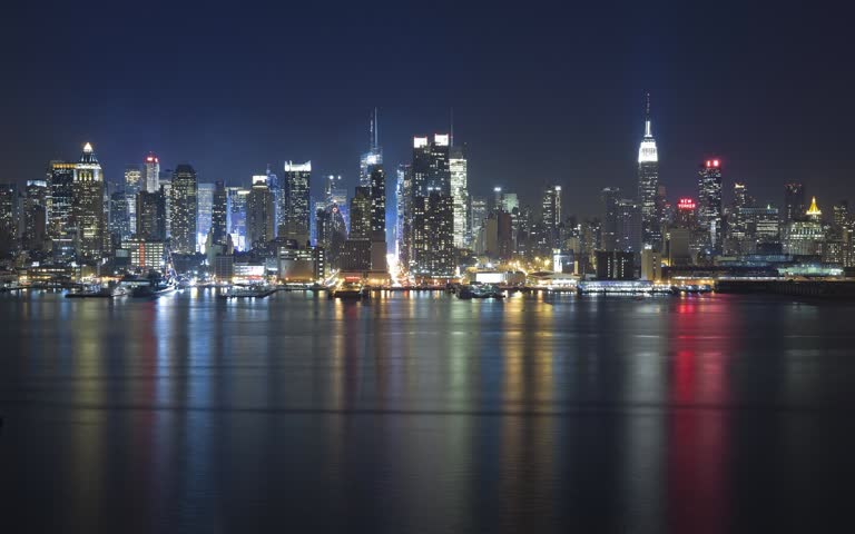 城市天际线的夜景,灯光倒映在水中