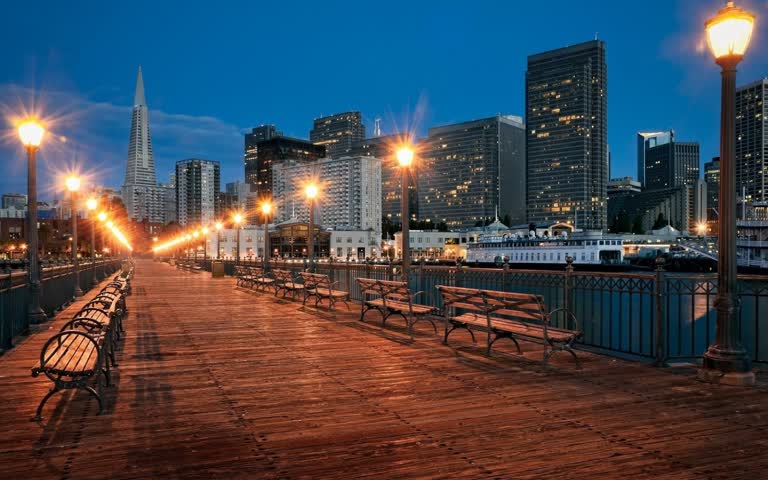 木板路的夜景,背景是长椅和城市灯光