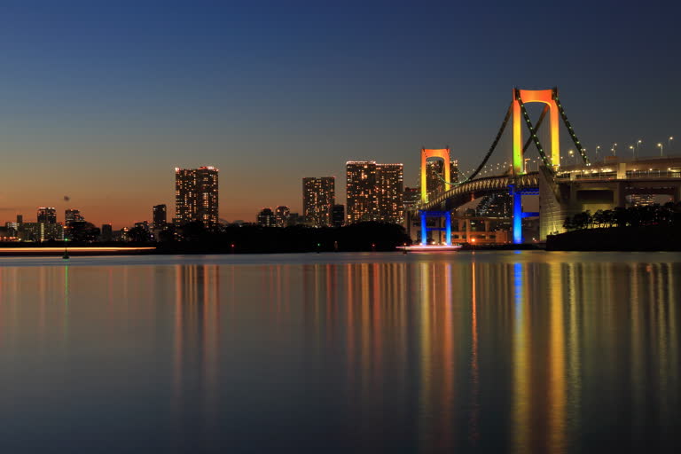 水体上的桥梁的夜景,背景是一座城市