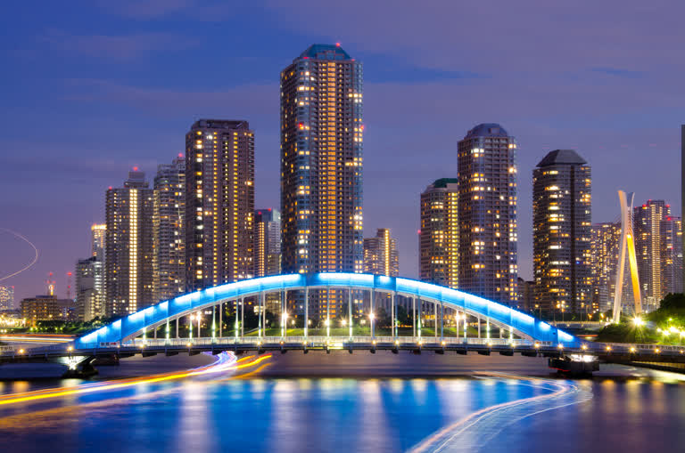 城市天际线的夜景,前景是蓝色的桥梁