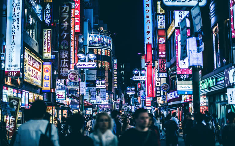 夜间人多走在拥挤的城市街道上