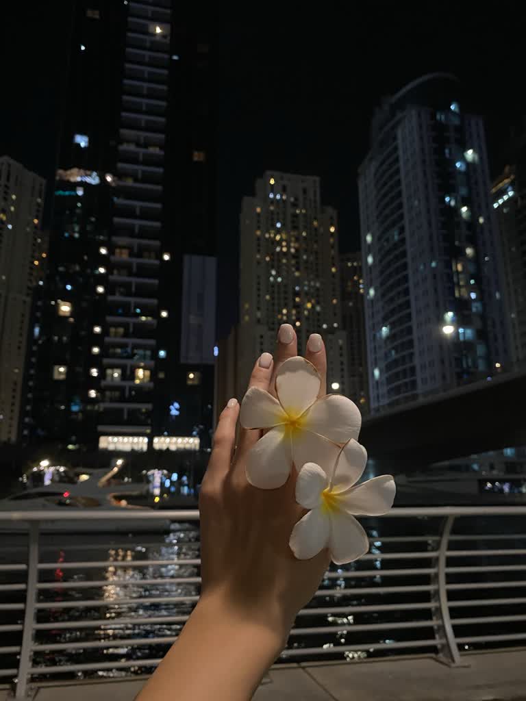有一个人手里拿着一朵花,靠近水体