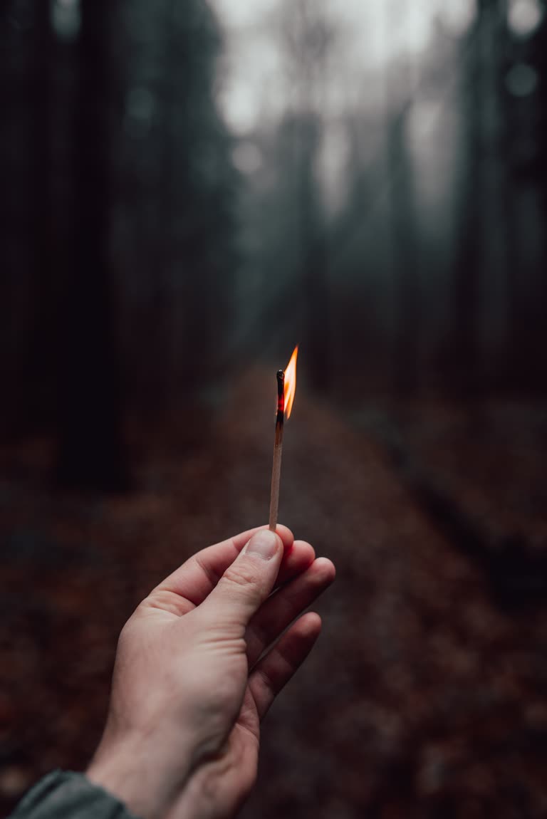 有一个人手里拿着一根点燃的火柴棍