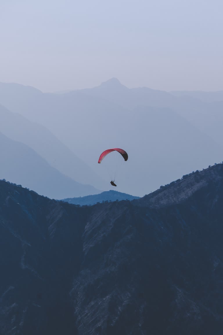 有一个人在山里滑翔伞