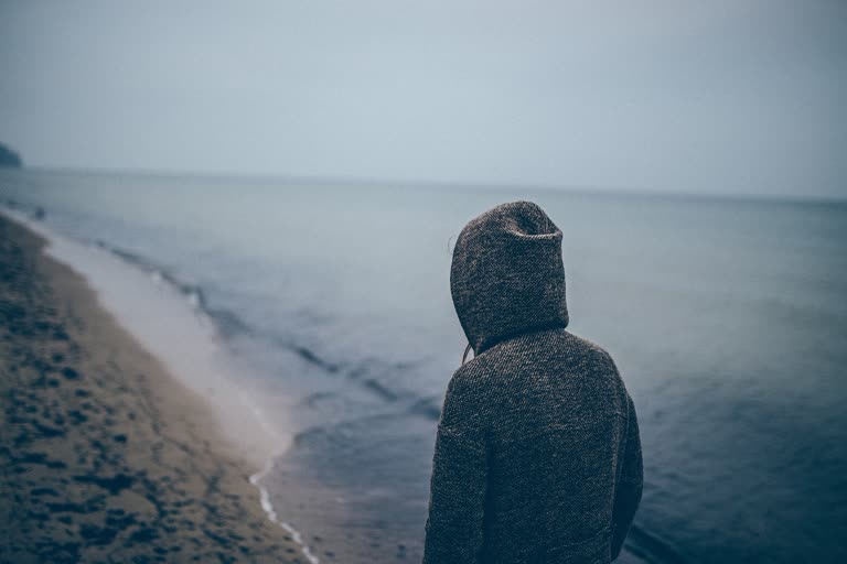 有一个人站在沙滩上看水