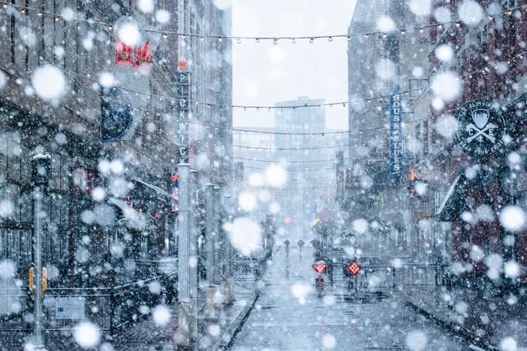 有一个人撑着伞在雪地里走在街上