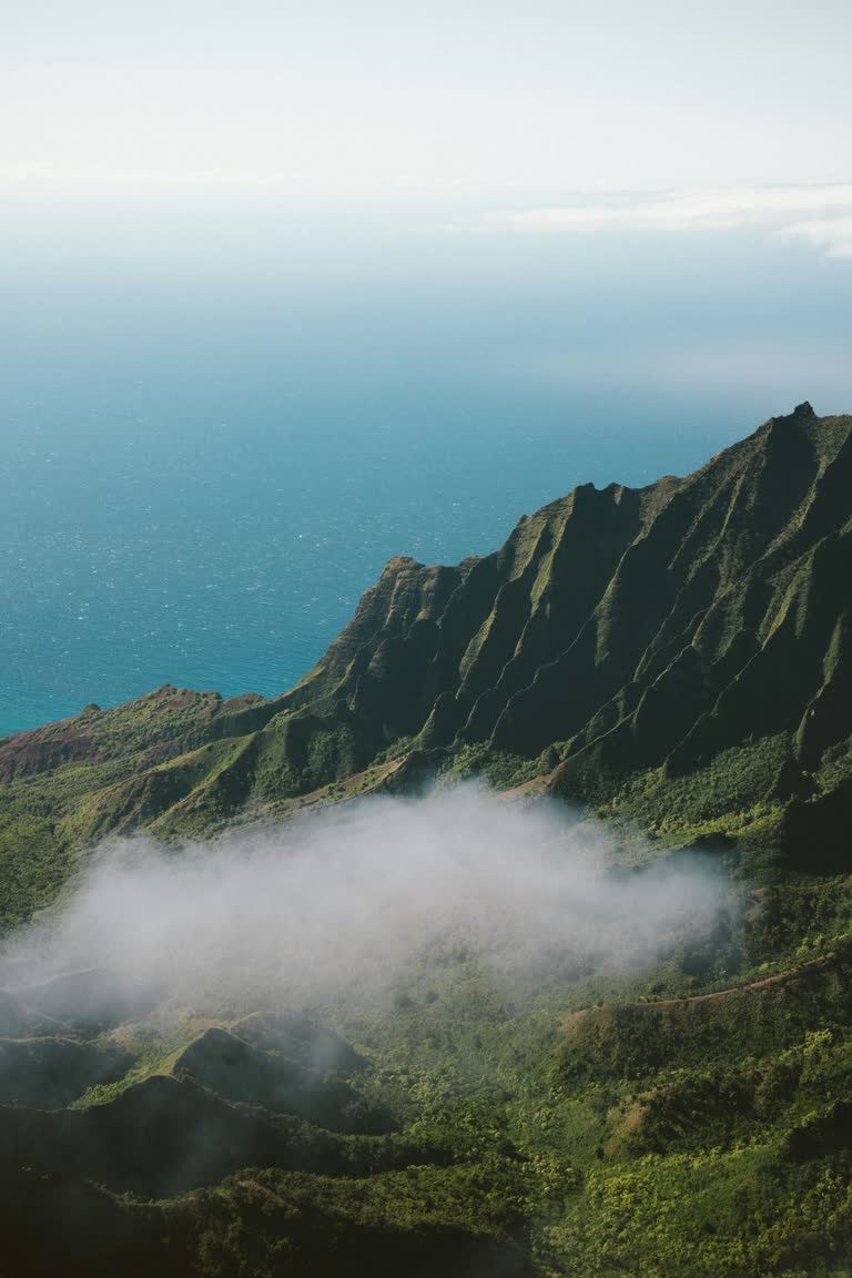 有一架飞机,正在海上飞越群山