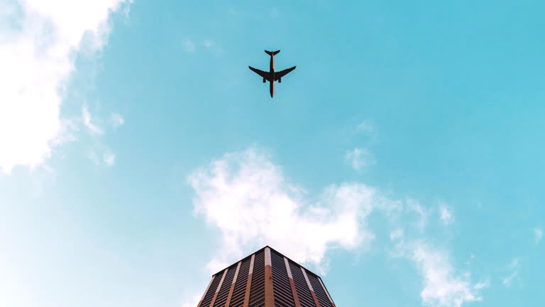 有一架飞机在天空中飞过一座建筑物