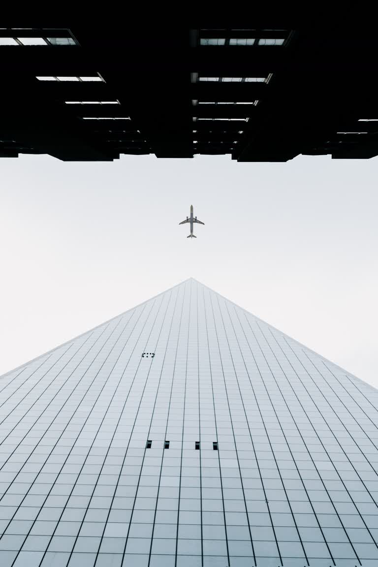 有一架飞机在天空中飞过一座建筑物