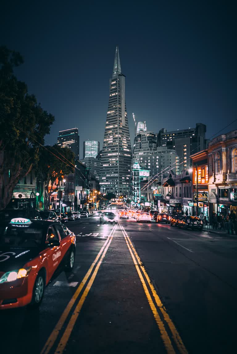 有一辆红色的汽车在夜晚的城市街道上行驶