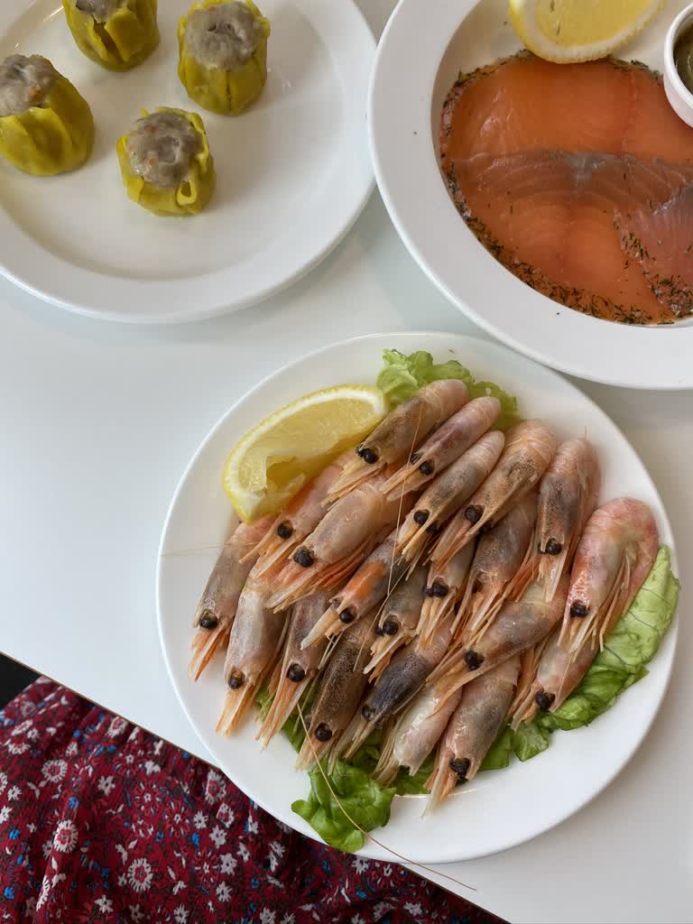 有几盘食物,包括虾、泡菜和酱汁