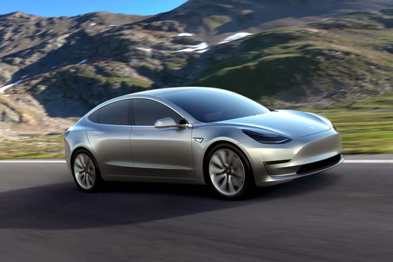 山里的路上有一辆银色的特斯拉Model 3