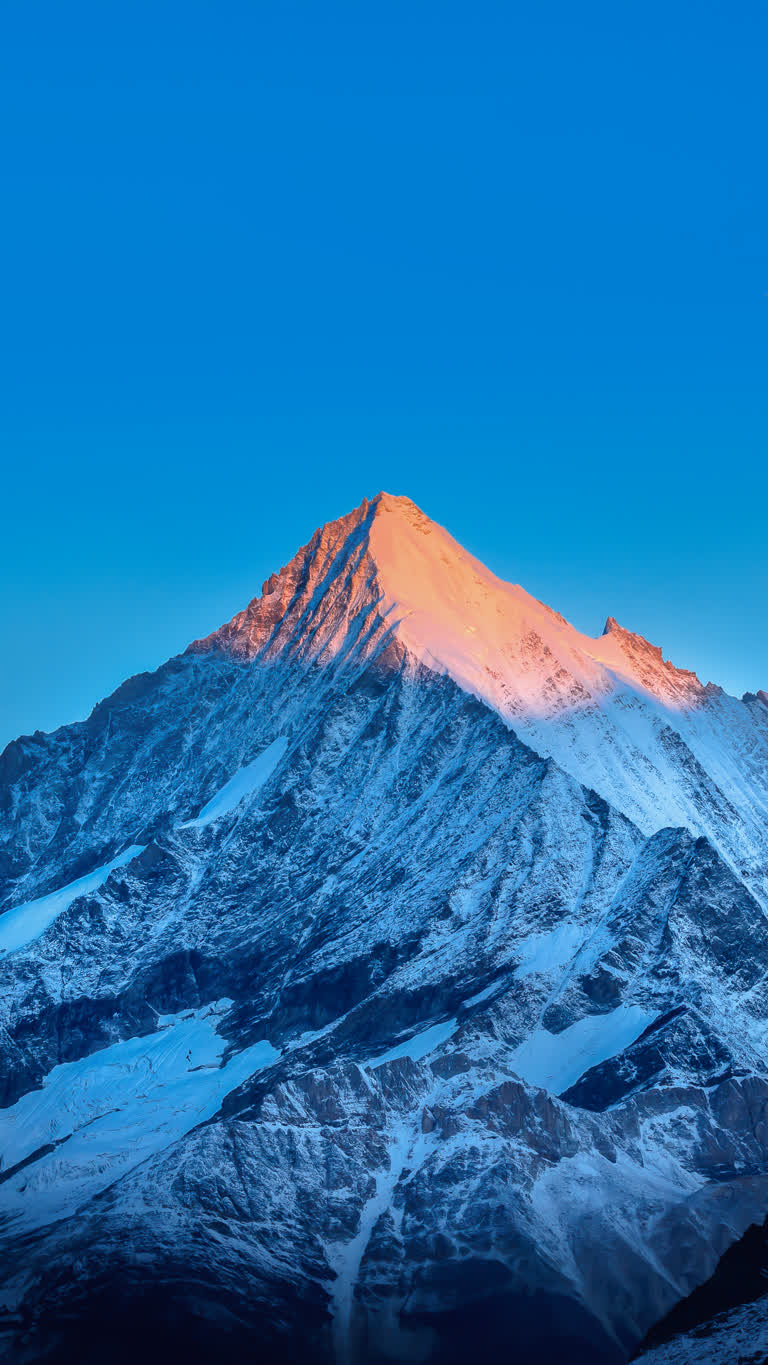 有一座白雪皑皑的山,背景是蓝天