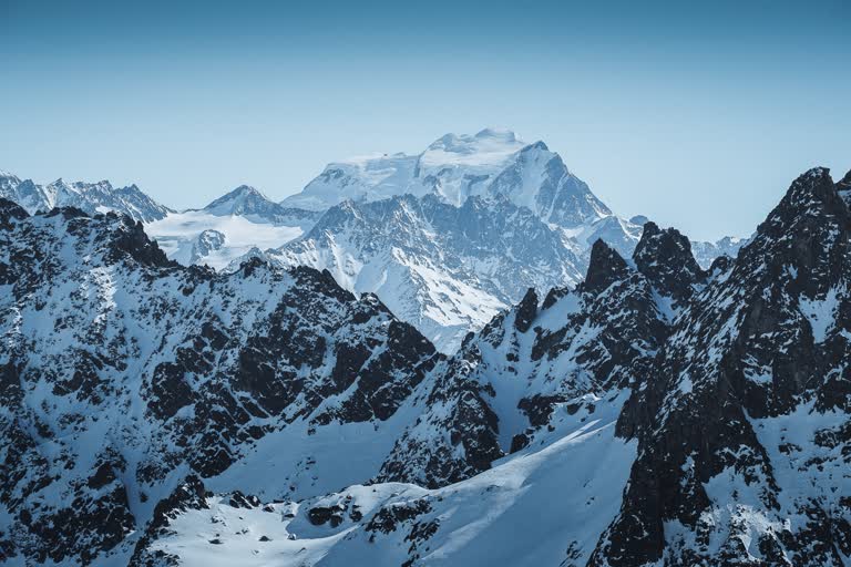 有一座白雪覆盖的山脉,上面有人在滑雪