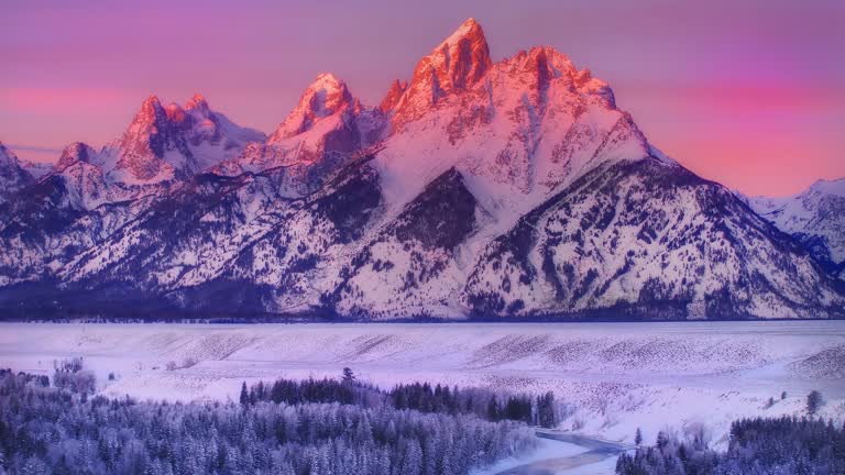 有一片白雪覆盖的山脉,前景是一条河流