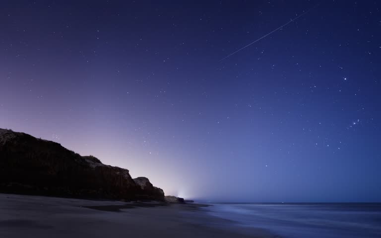 海滩上的星夜,喷气式飞机在天空中飞行