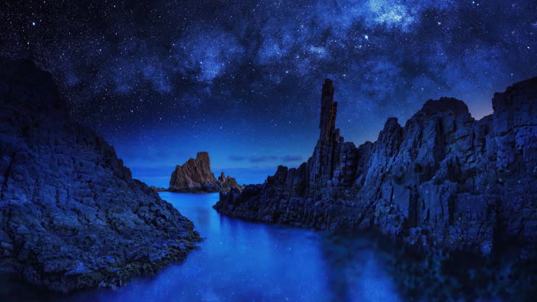 被大岩石包围的水域上繁星点点的夜空