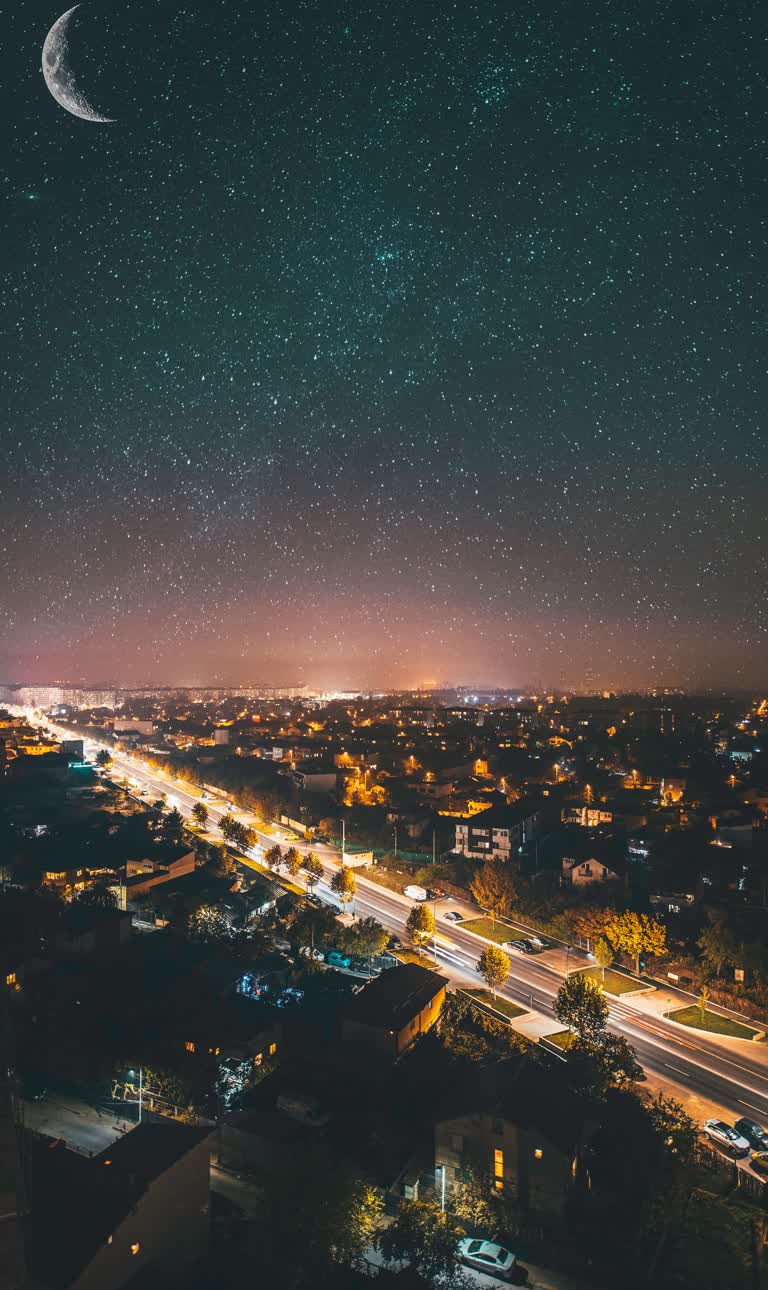 城市上空繁星点点的夜空,远处有新月形