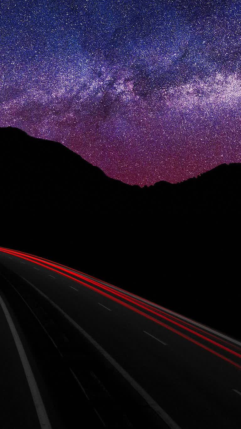 高速公路上空的星空和带有红光条纹的山脉