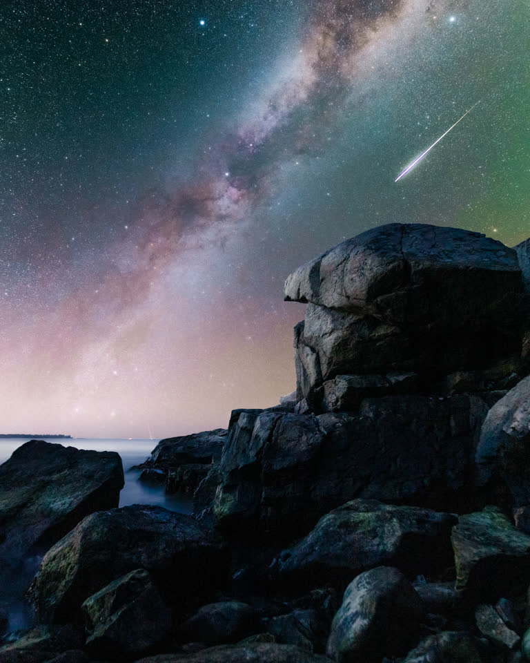 岩石海滩上繁星点点的夜空,流星璀璨